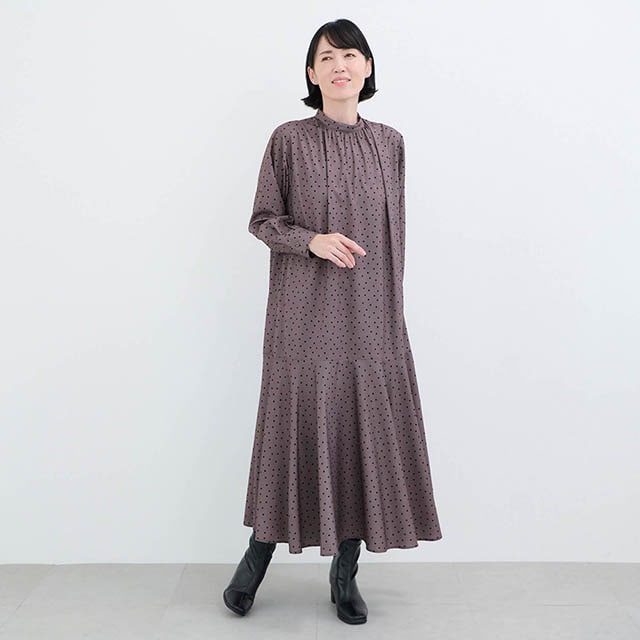 すっきりとしたスタンドネックに首元からバストにかけたギャザーデザインがポイント