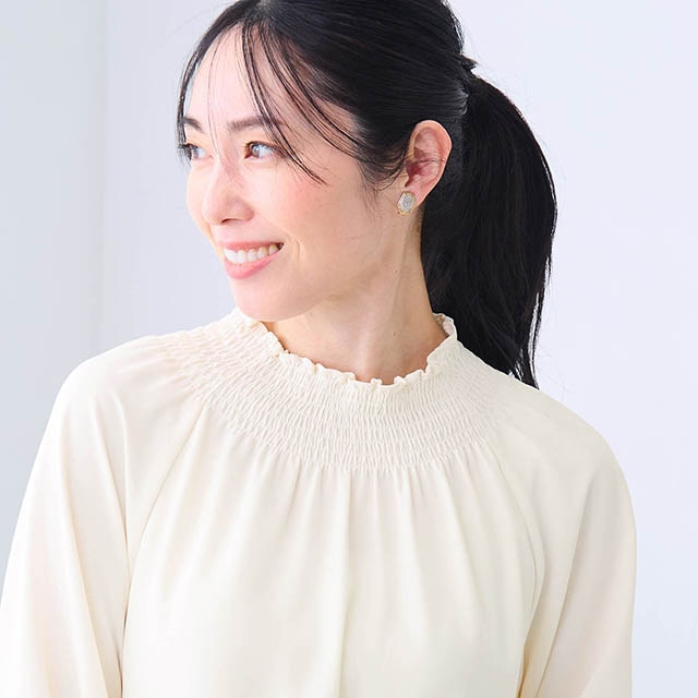 首元と袖口にシャーリングが施された華やかなブラウス