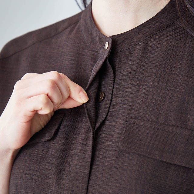 ゴールドカラーの第一ボタンをあしらった比翼仕立て