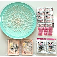 菊花のように盛り付けられた淡泊でもっちりとしたふぐ刺し、熱燗に入れてひれ酒が味わえるとらふぐ焼きひれ