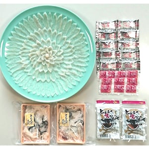 菊花のように盛り付けられた淡泊でもっちりとしたふぐ刺し、熱燗に入れてひれ酒が味わえるとらふぐ焼きひれ