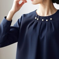襟元に配したパール調ボタンで、アクセなしでも華やかに