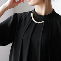 襟もとのパール調ネックレスはエレガントな印象に