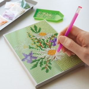 ダイヤモンドフィックスは、ノリ付きのキャンバスに専用ビーズを貼って作る技法付属の専用ペンで図案どおりにビーズを貼るだけなので初心者にもおすすめ専用ペンが付くので、届いたらすぐに作り始められるキャンバス