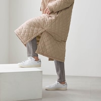 裾のサイドスリットはボタン付きで、シーンに合わせて使える