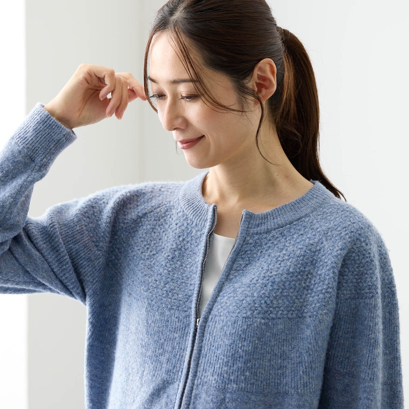 胸元から背中まで入った立体感のある編み柄が大人っぽい印象