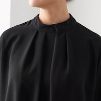 胸元を立体的に見せるスタンドネックからのタック