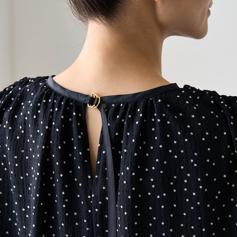 後ろは襟のパイピングから続いた紐がさりげないアクセントに
