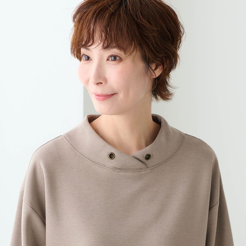 フード見えするスタンドネックとアンティークゴールド調のアイレットがさりげなく上品