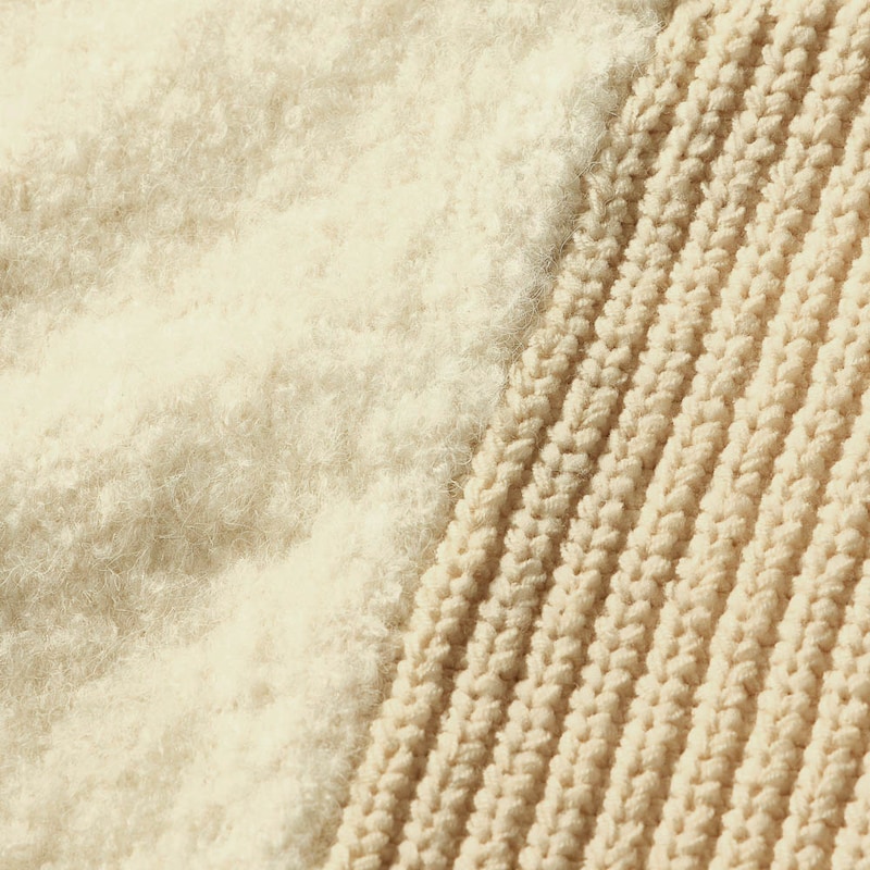 前身頃は畔編み、袖部分はふんわりとしたブークレー糸で編み上げた切り替えデザイン