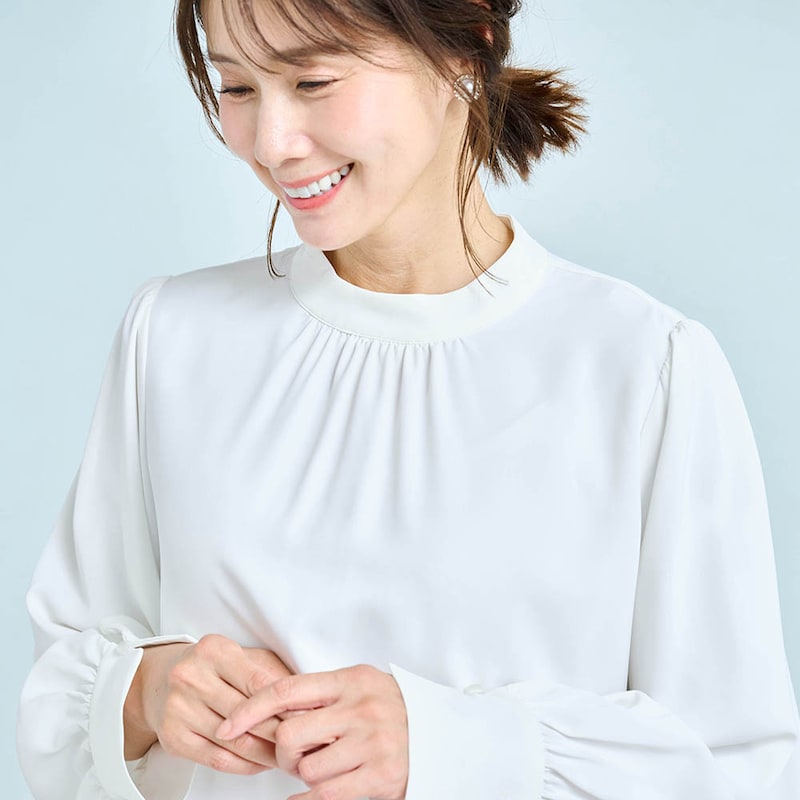 スタンドネックと胸元のギャザーで立体的なデザイン