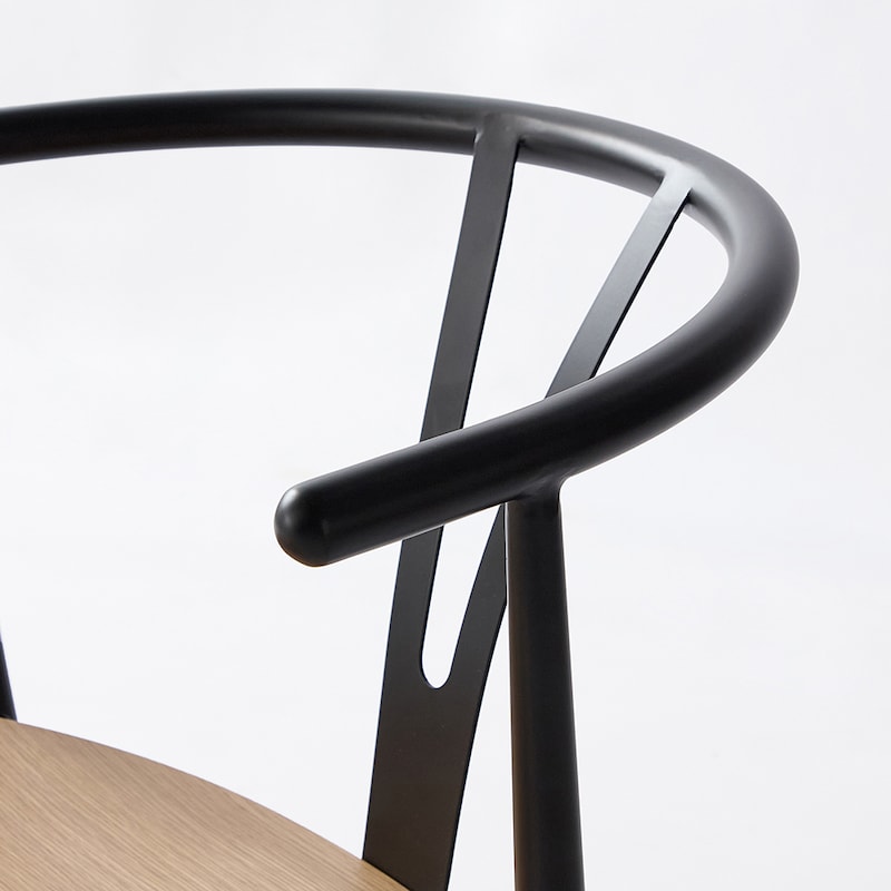 スチール製ひじかけとゆったり背もたれに、マットな黒い塗装