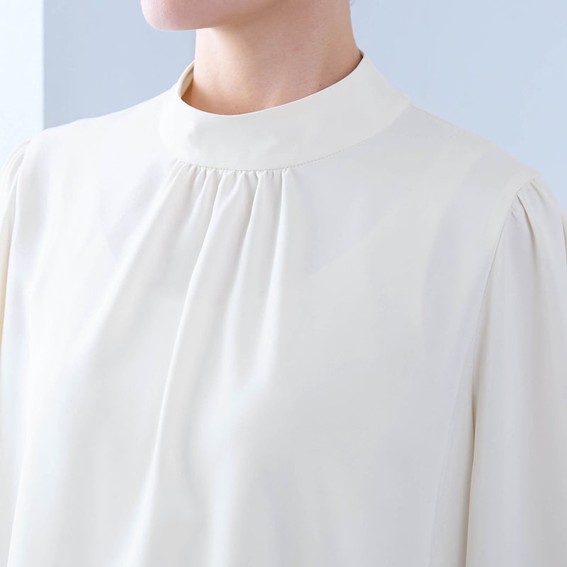 ギャザー仕様のハイネックで顔まわりを華やかに