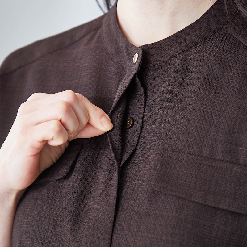 ゴールドカラーの第一ボタンをあしらった比翼仕立て 