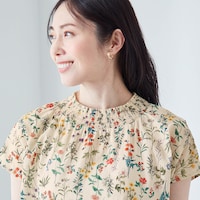 やや高めの襟が首まわりをカバーし、シャーリングで華やぎを演出