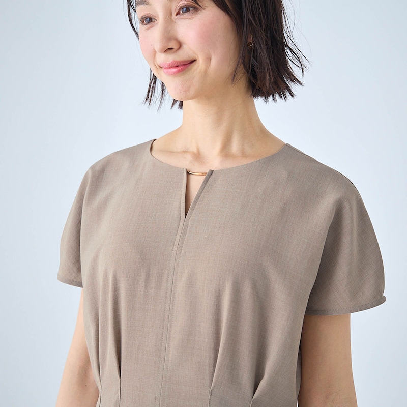 首元で光るゴールド色の飾りがアクセント