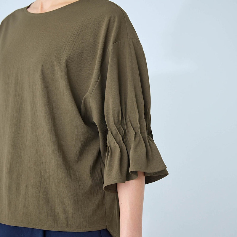 肘まで覆う丈感のフレア袖が二の腕をカバー