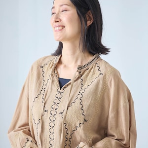 生地と同色の糸と配色の糸で刺繍を施した、民族衣装のようなデザイン