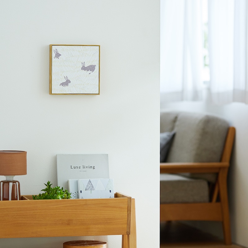 くすっと笑いたくなる、タフな顔のうさぎが草むらの中から顔を覗かせています。