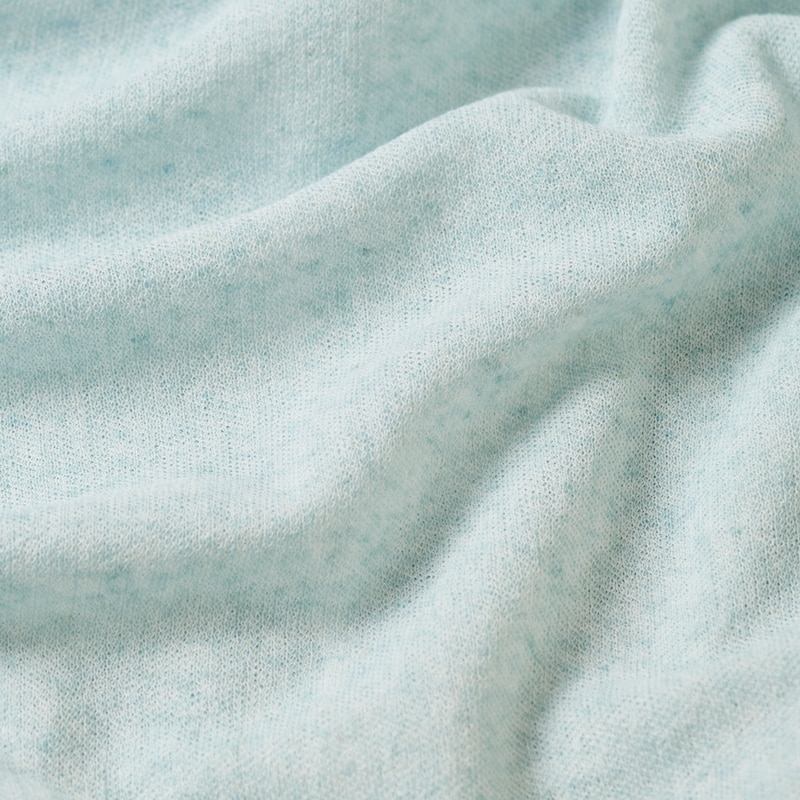 カラーと白糸をブレンドした杢調の糸で編んだニュアンスカラーのニット