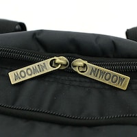MOOMIN』のロゴが刻印されたファスナートップ